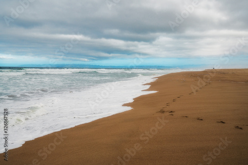 Fototapeta Naklejka Na Ścianę i Meble -  Scenic seascape. Wide sandy beach, stormy sea, and beautiful cloudy sky background