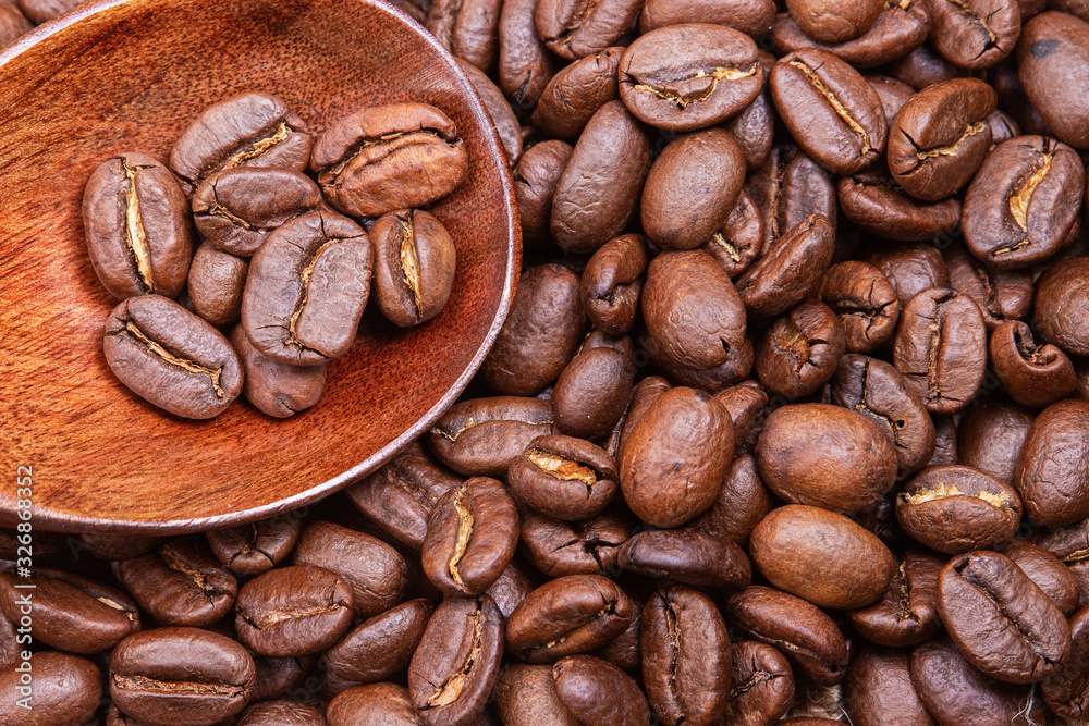 Naklejka premium Roasted coffee beans with a spoon.