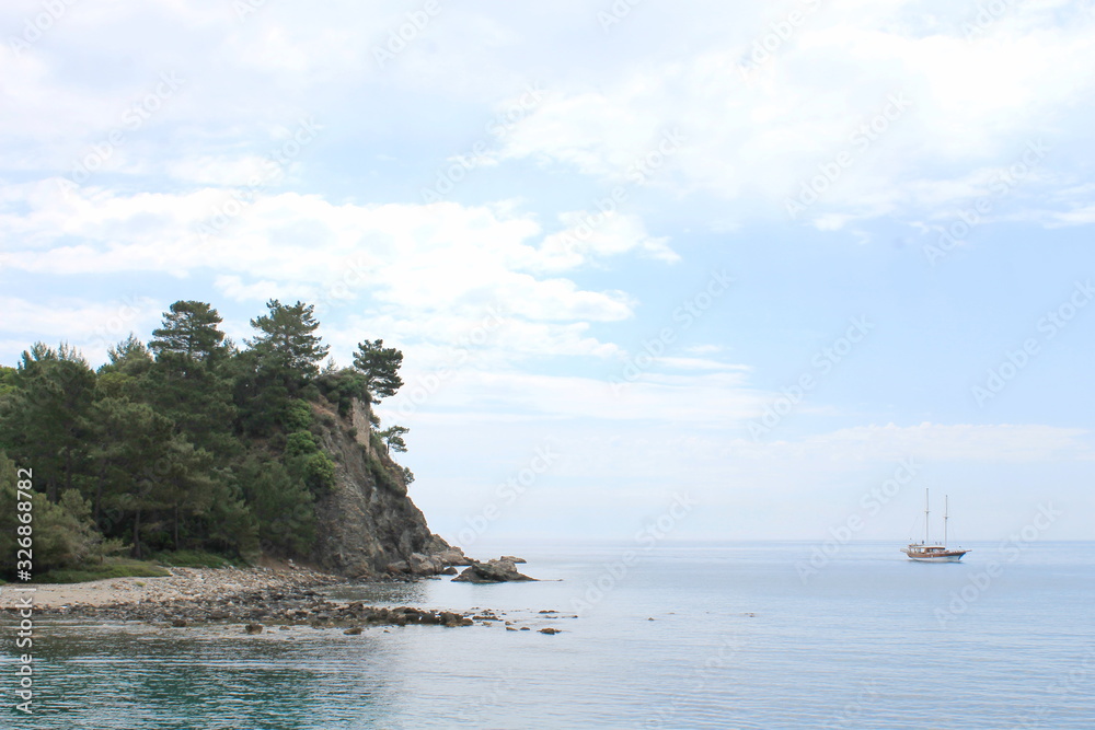 Obraz premium Pirate yacht appearing from behind the cliff