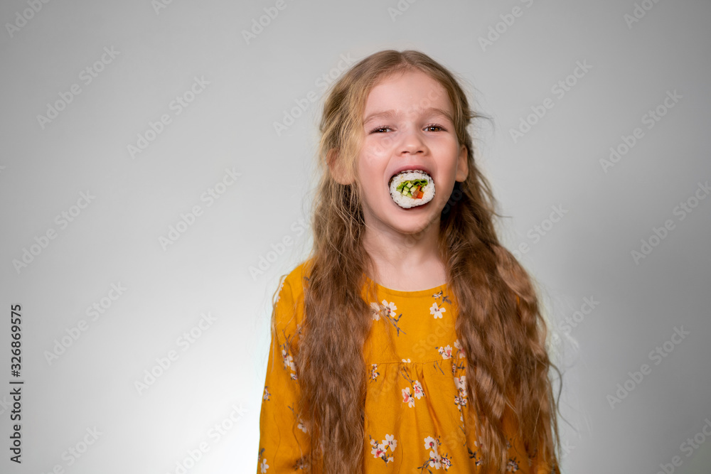 little Girl puts roll in mouth, looking at camera little Girl puts roll in mouth, looking at camera