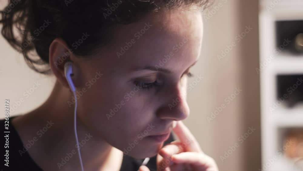 Young woman wearing headphones with laptop, teenage student studying online at home, listening to audio course Young woman wearing headphones with laptop, teenage student studying online at home, listening to audio course