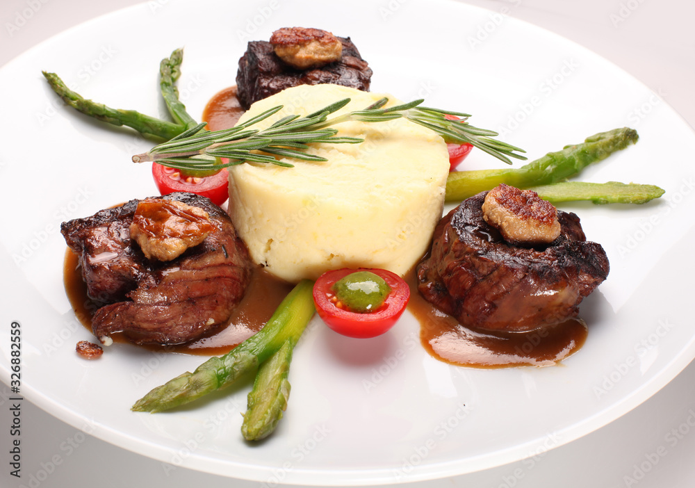 Filet mignon with asparagus and mashed potatoes on a white plate. Filet mignon with asparagus and mashed potatoes on a white plate.