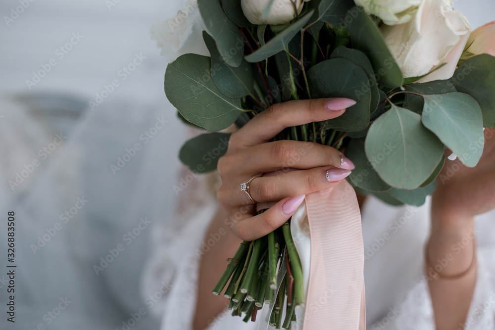 bride holds a wedding bouquet of roses