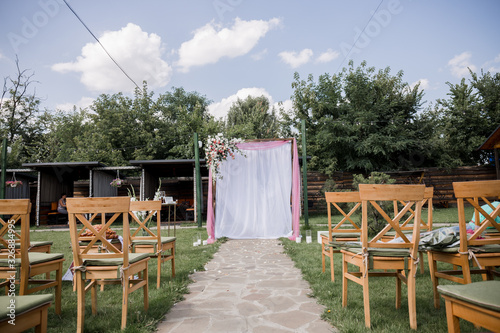wedding ceremony arch decorated with flowers with chairs © dyachenkopro