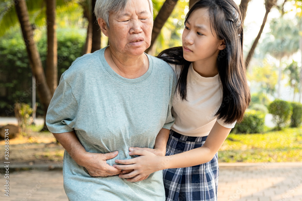 Asian senior woman hands touching stomach painful,sick female patient