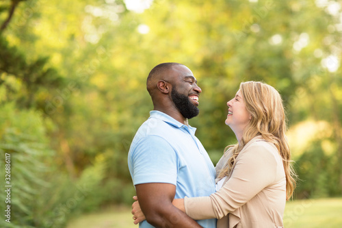 Loving mixed race couple hugging and laughing.