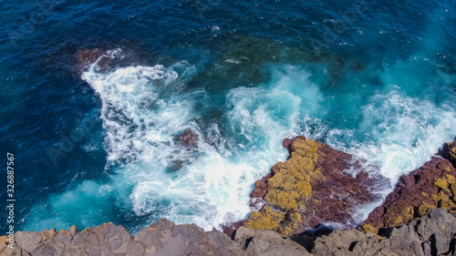 Aerial view of ocean waves and fantastic Rocky coast at Australia. Danger sea wave crashing on rock coast with spray and sunshine in Australia