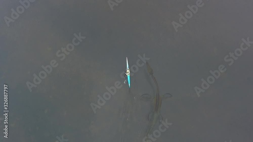 Aerial view. Dragon, a monster of prehistoric era, swims underwater next to kayak, Ness Monster photo