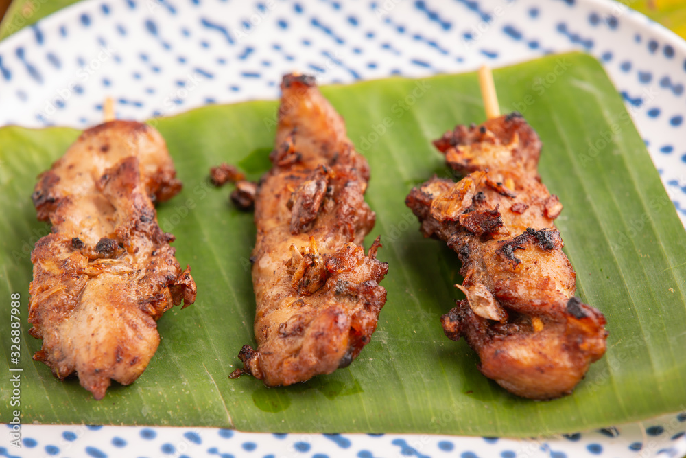 Grilled pork skewers put on the ground, green banana stump leaves Grilled pork skewers put on the ground, green banana stump leaves