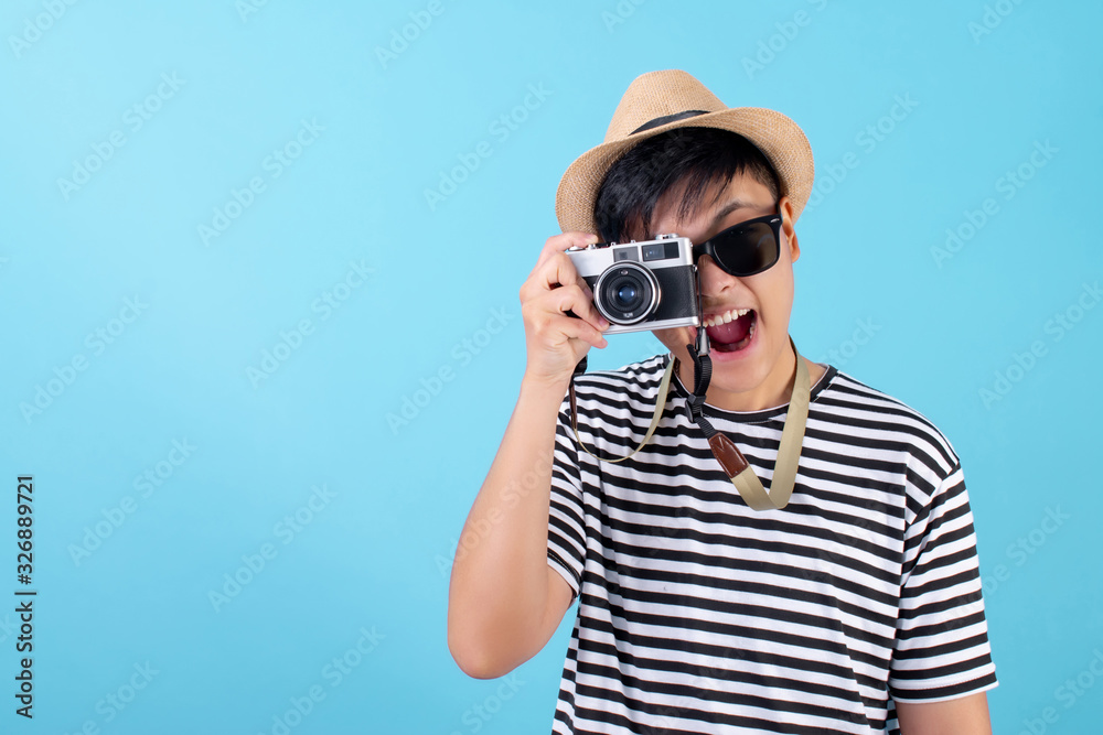Young Asian travelers are taking pictures in the blue studio. Isolated background Young Asian travelers are taking pictures in the blue studio. Isolated background