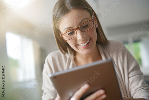 Portrait of woman at home connected with digital tablet