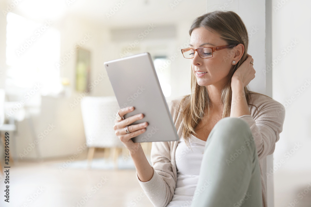 Woman at home relaxing and websurfing with digital tablet Woman at home relaxing and websurfing with digital tablet