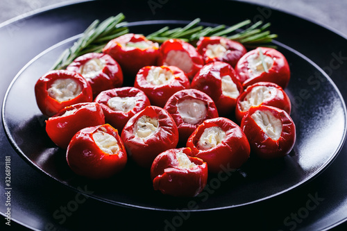Hot red tiny cherry peppers on a black plate