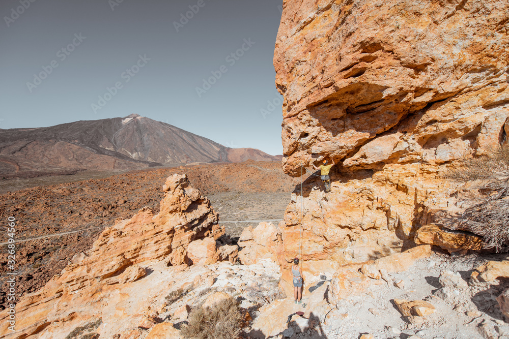 Beautiful rocky landscape on the volcanic valley with unrecognisable climbers and Teide volcano on the background during a sunny day