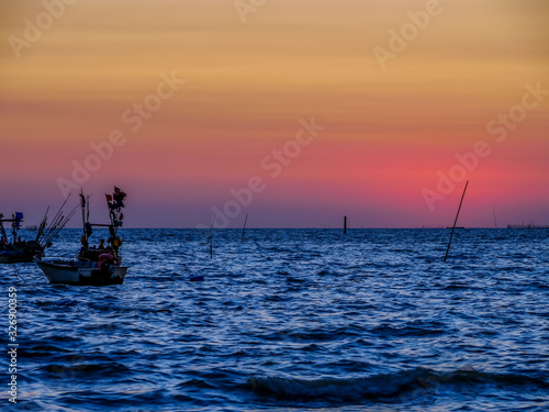 Photos of the small fishing boat moored in the ocean.