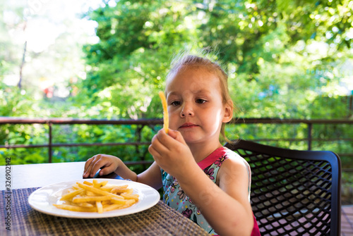 child eats french fries. not healthy food