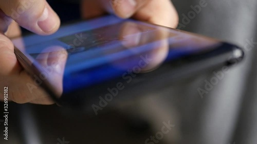 An extreme closeup with shallow DOF shot of someone scrolling through social media posts on a smartphone's touchscreen. photo