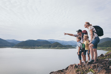 Happy family standing near the lake at the day time.