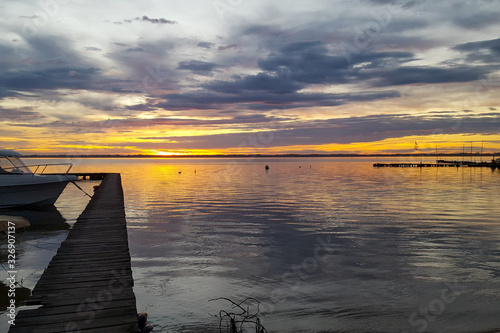 Fototapeta Naklejka Na Ścianę i Meble -  sunrise wood pontoon in water lake sunset sun in water yellow sky