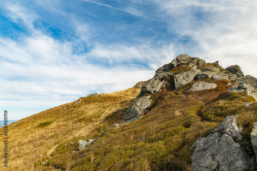 mountain top lonely rocky stone peak highland scenic view with blue sky white clouds background
