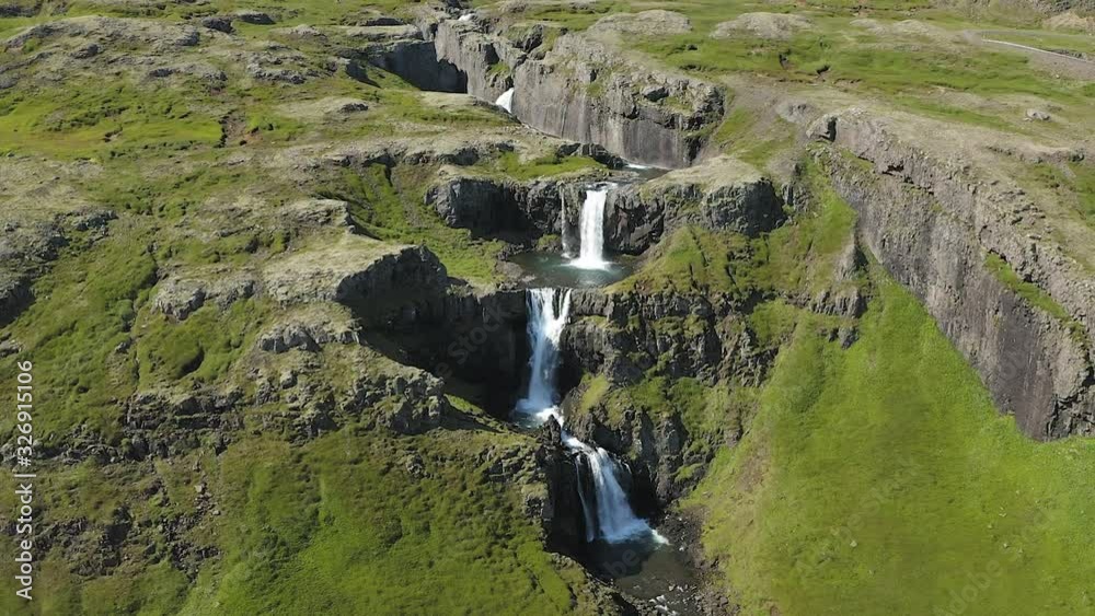 Klifbrekkufossar waterfall in Iceland. Flight forward, tilt and zoom in. Mossy and rocky green mountain landscape. Nordic nature. Klifbrekkufossar waterfall in Iceland. Flight forward, tilt and zoom in. Mossy and rocky green mountain landscape. Nordic nature.
