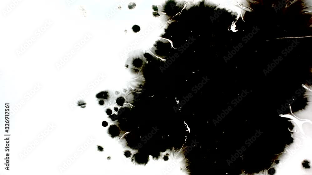 Black ink drops splatters spilling on white background