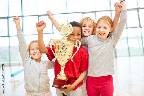 Kinder Mannschaft jubelt mit einem Pokal photo