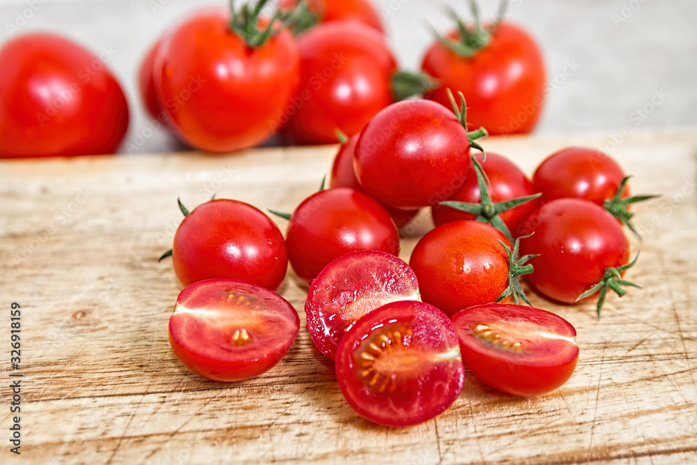 Cherry tomatoes on a wooden cutting board. Vegetable background. Bio products. Cherry tomatoes on a wooden cutting board. Vegetable background. Bio products.
