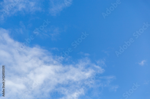 Bright blue sky with whispy white cloud - copy space