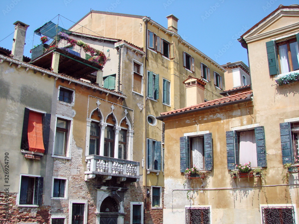 Bottom view of ancient Venetian street buildings on a clear sunny day.