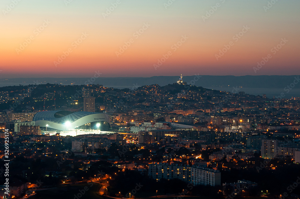 Panoramic shot of the city of Marseille and Orange Velodrome stadium at sunset and golden hour from the hills around the town
