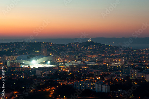 Panoramic shot of the city of Marseille and Orange Velodrome stadium at sunset and golden hour from the hills around the town photo