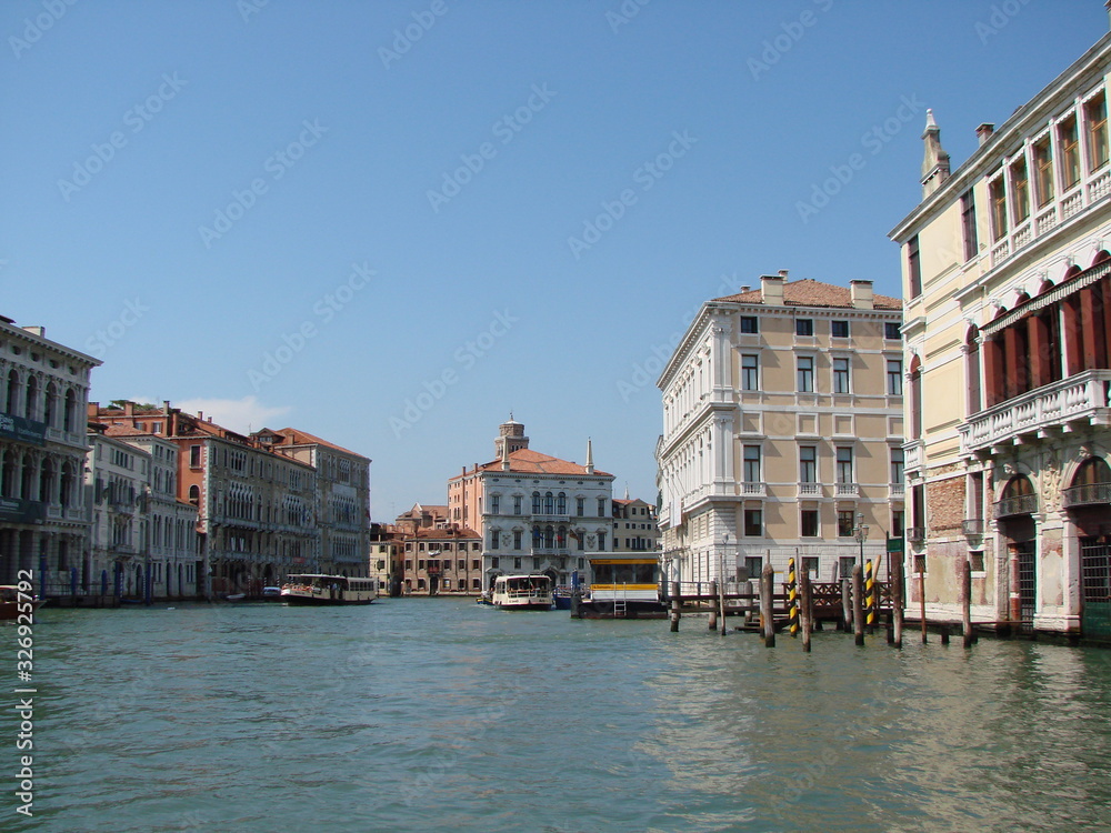 The beauty of the unique Venetian architecture surrounded by water streets and avenues against the backdrop of a clear blue summer sky.