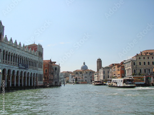 The beauty of the unique Venetian architecture surrounded by water streets and avenues against the backdrop of a clear blue summer sky.