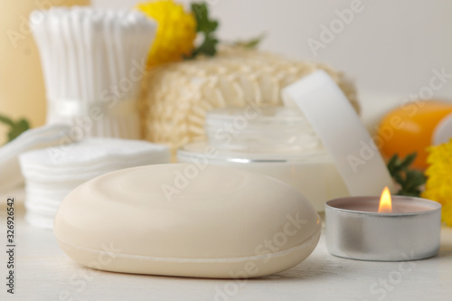 Various personal care products. Soap close-up, cotton pads and sticks and yellow flowers on a white background