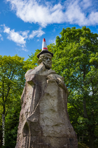 The statue of Thomas Carlyle, a British historian, satirical writer, essayist, translator, philosopher, mathematician, and teacher, at Kelvingrove Park in Glasgow, Scotland sports a traffic cone.  photo