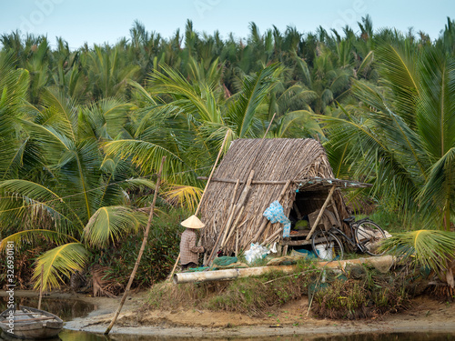 Fisherman's hut with canoe and person along the mekong river in Vietnam