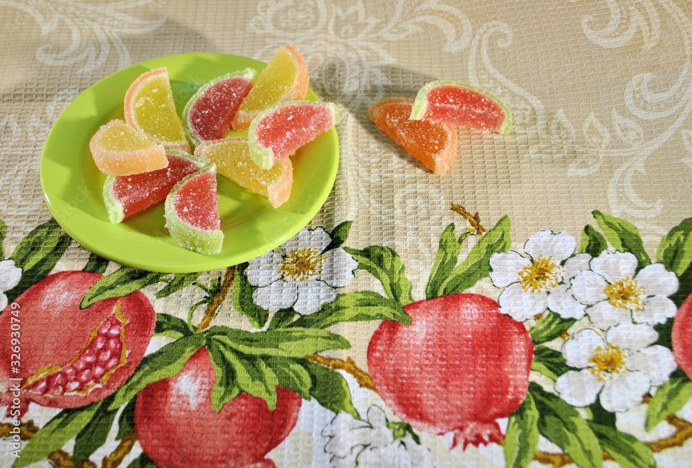 Naklejka premium Candied fruit jelly appetizer gourmet meal fruits colored marmelade green plate background