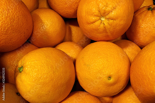 A box of ripe oranges on a grocery store counter. Background food texture photo