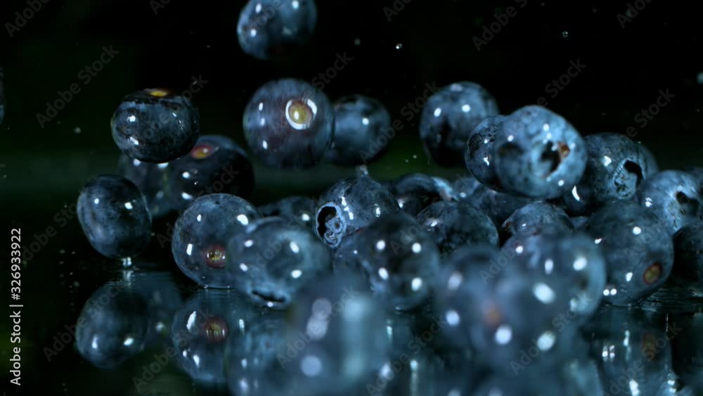 Super Slow Motion Shot of Fresh Blueberries Falling into Water and Splashing at 1000fps.
