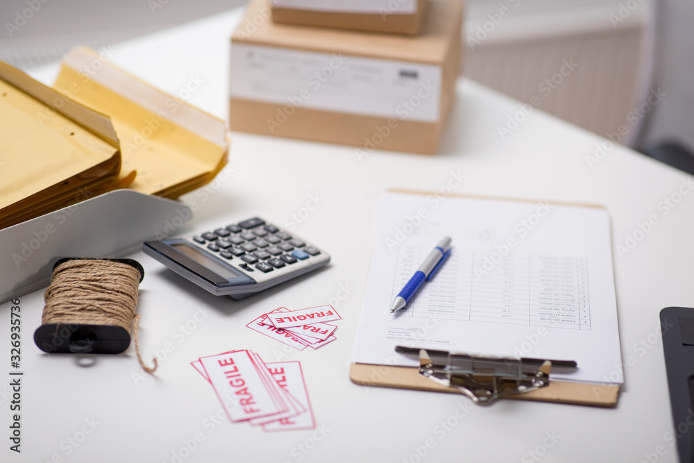 delivery, mail service and shipment concept - calculator, clipboard, rope and envelopes at post office delivery, mail service and shipment concept - calculator, clipboard, rope and envelopes at post office