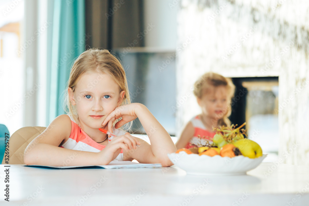 little girl at the table with a notebook little girl at the table with a notebook