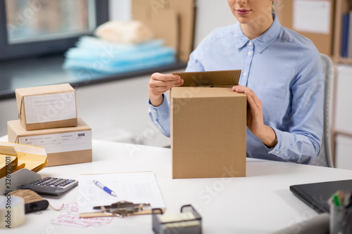 Fotografia delivery, mail service, people and shipment concept - close up of woman packing