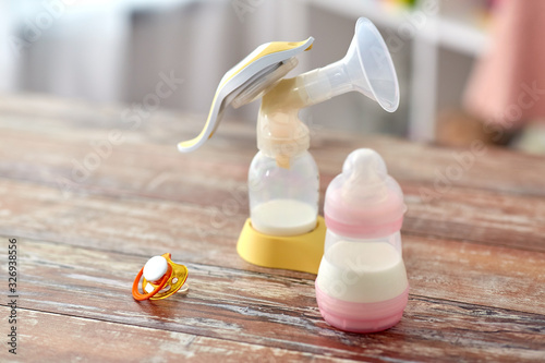 Fényképezés feeding concept - bottle with baby milk formula, soother and breast pump on wood