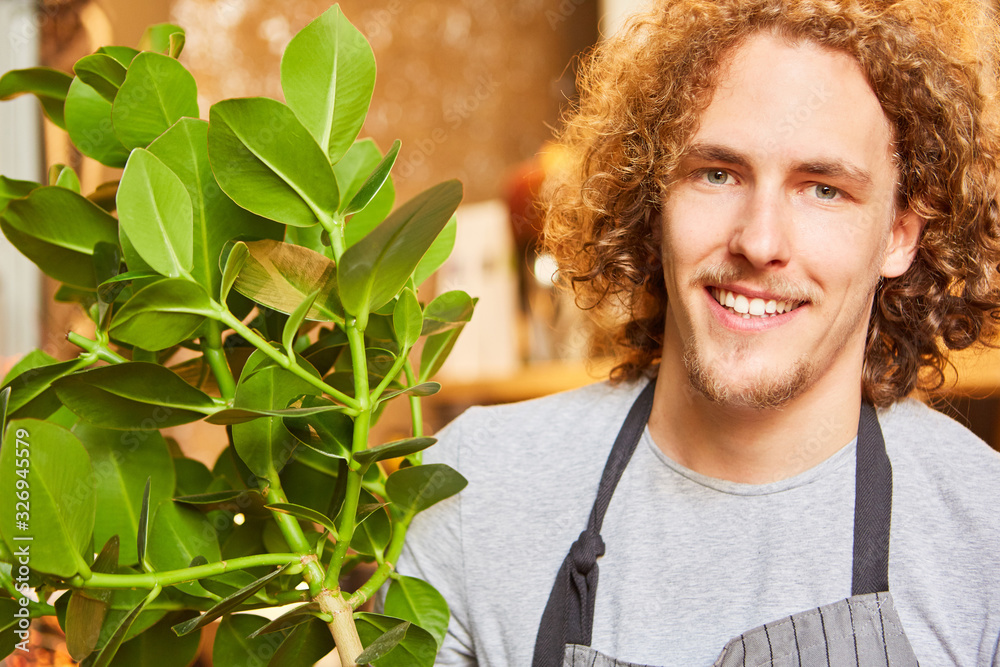 Young florist on delivery of a green plant Stock Photo | Adobe Stock