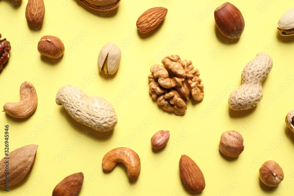 Different delicious nuts on yellow background, flat lay Different delicious nuts on yellow background, flat lay