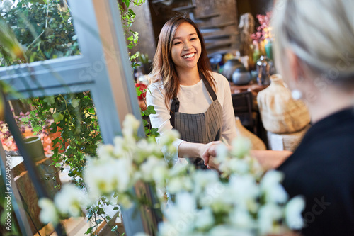 Florist welcomes customer with handshake in flower shop