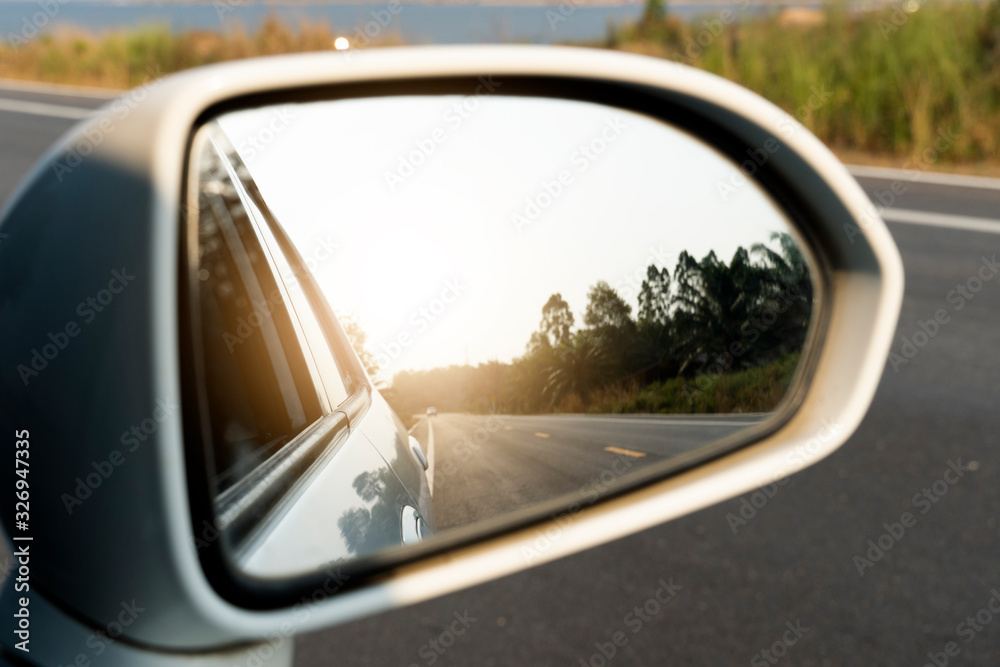 Mirror view of white car on the road heading towards the goal of the trip. Mirror view of white car on the road heading towards the goal of the trip.