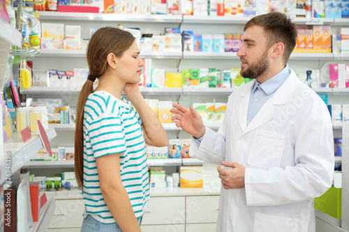 Professional pharmacist working with customer in modern drugstore © New Africa