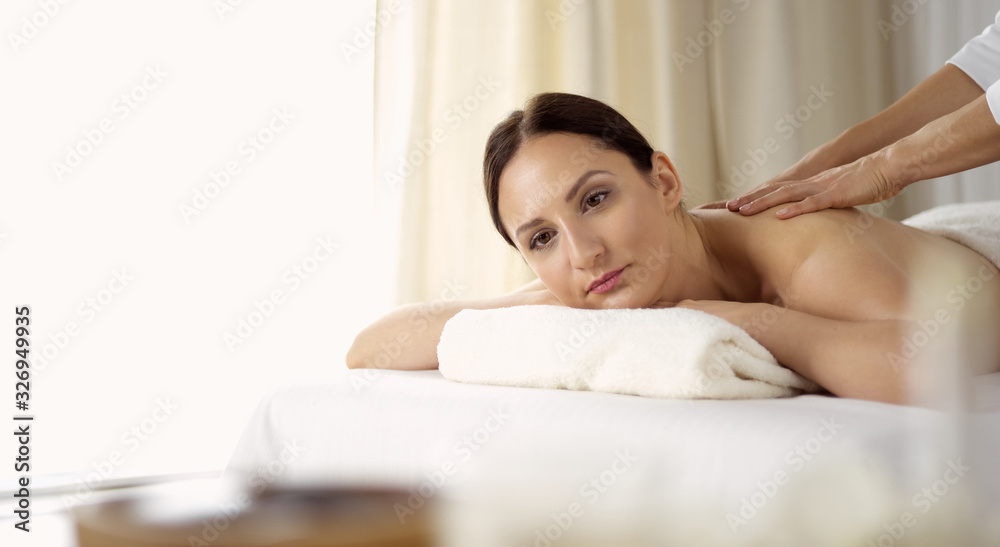 Pretty brunette woman enjoying procedure of back massage in spa salon. Beauty concept Pretty brunette woman enjoying procedure of back massage in spa salon. Beauty concept